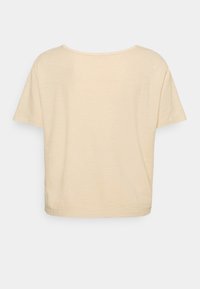 Cremefärgad kortärmad t-shirt med rund halsringning, mjuk textur och avslappnad passform, med en enkel baksida utan mönster eller detaljer.