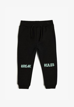 Zwarte sweatpants met een verstelbare tailleband, voorzien van de tekst "BREAK" en "RULES" in lichtblauwe letters op elk been. Gemaakt van zachte, gestructureerde stof.