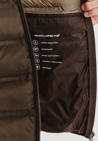 Czarna, ocieplana kurtka z wodoodpornym i wiatroszczelnym wnętrzem, z etykietkami przedstawiającymi cechy: ekologiczna, izolacja termiczna, pakowna.