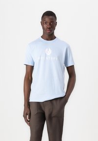 Lichtblauwe katoenen t-shirt met een ronde hals en korte mouwen, met een wit "BELSTAFF" logo en embleem op de borst.