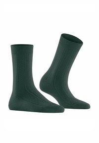 Chaussettes tricotées vertes avec des côtes en haut, arborant un motif texturé, un talon et un orteil renforcés, et un design mi-mollet.