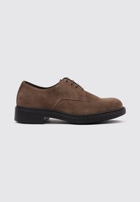 Zapato de gamuza marrón con cordones, de punta redonda y una suela de goma negra resistente. Presenta costuras sutiles a lo largo de los bordes y seis orificios para los cordones.