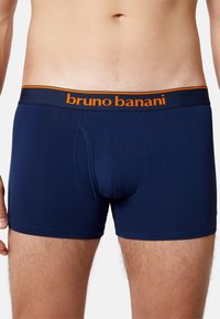 Granatowe bokserki wykonane z miękkiego materiału, z pomarańczowym logo "bruno banani" na elastycznej talii oraz wygodnym krojem.