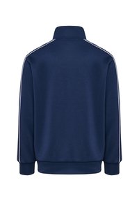 Marinblå atletisk jacka i slät tyg, med hög krage, långa ärmar och vita randiga detaljer vid axlarna.