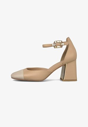 Zapato beige de tacón ancho cerrado en la punta con correa en el tobillo y hebilla rectangular decorativa con cristales de imitación.