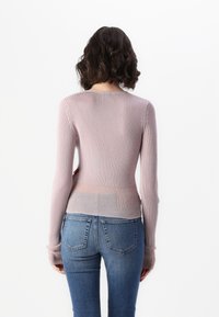 Lys rosa ribbestikket langermet topp med en slimfit design. Har en rund halslinje og en subtil gradient til en lysere nyanse ved kanten.