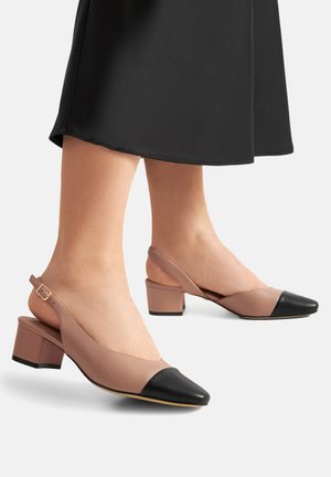 Beige un melni siksniņu apavi ar izteiktu purngali, potītes siksniņu un zemu blokveida papēdi. Gluda āda ar kontrastējošu purngali.