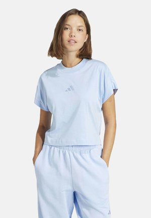 T-shirt in cotone azzurro chiaro con maniche corte e scollatura a girocollo. Presenta un logo Adidas tono su tono sul petto.