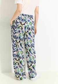 Pantaloni con fascia elastica colorata e stampata, caratterizzati da una combinazione di design geometrici blu, verdi e rosa, con tasche laterali e una vestibilità comoda.