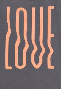 Textil gris con la palabra "AMOR" en letras onduladas de color coral. El diseño presenta líneas suaves y fluidas con una textura suave.