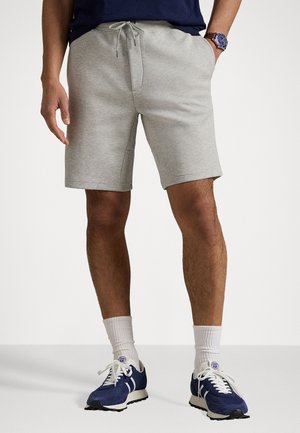 Gray cotton blend shorts with an elastic waistband and drawstring, featuring side pockets and a relaxed fit. Worn with athletic shoes.