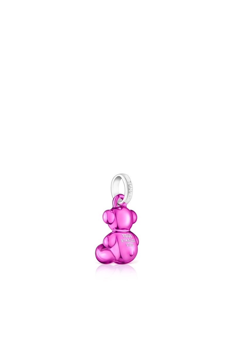 Charm en forma de oso de peluche rosa, hecho de un material brillante, con formas redondeadas, un lazo plateado y detalles grabados en la parte posterior.