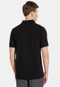 Czarna koszulka polo z teksturowanej tkaniny, posiadająca krótki rękaw, klasyczny kołnierzyk oraz subtelne poziome paski.