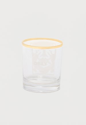 Verre transparent avec un fin bord doré autour du bord supérieur, posé sur un fond blanc uni.