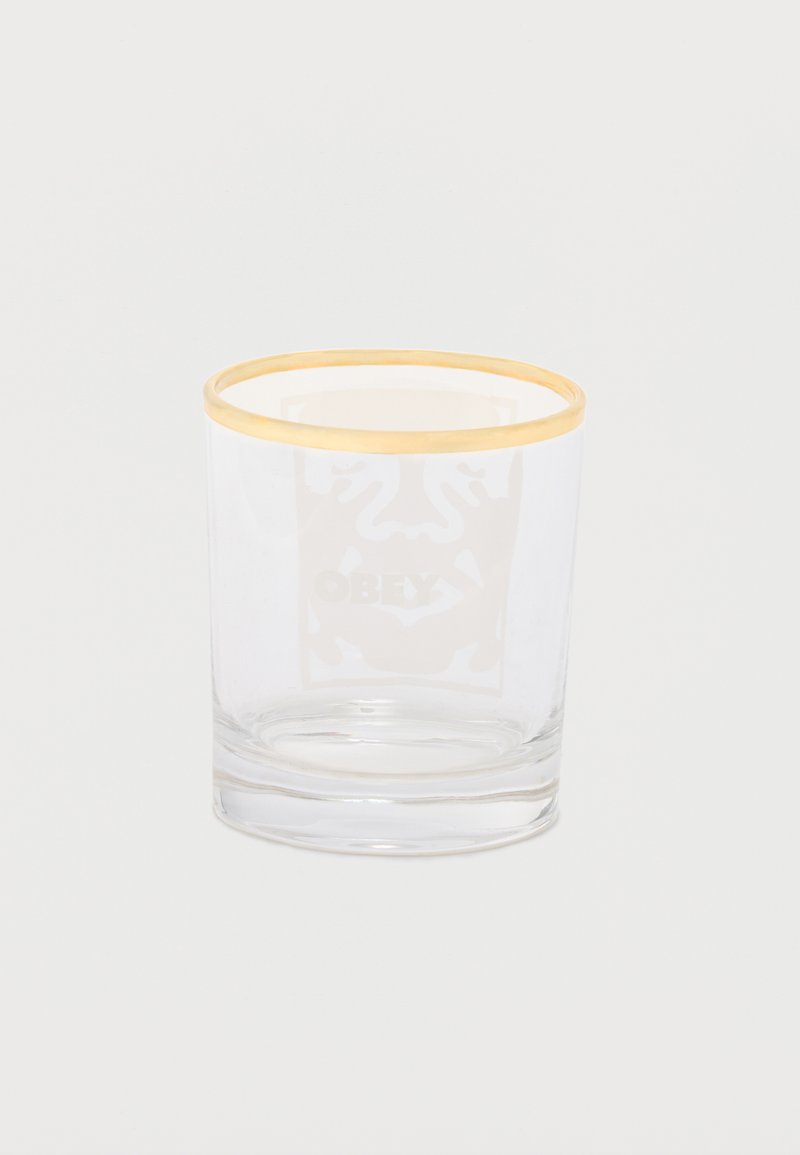 Διάφανο γυάλινο ποτήρι με λεπτή χρυσή περίμετρο στην πάνω άκρη, τοποθετημένο σε απλό λευκό φόντο.