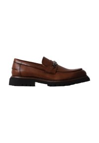 Mocassin en cuir marron avec semelle noire épaisse et détail chaîne en métal sur le dessus, présenté sur fond blanc, vue de profil.