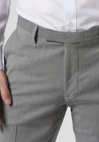 Graue, maßgeschneiderte Hosen mit glatter Textur, flachem Vorderteil, Gürtelschlaufen und feinem Nadelstreifenmuster.