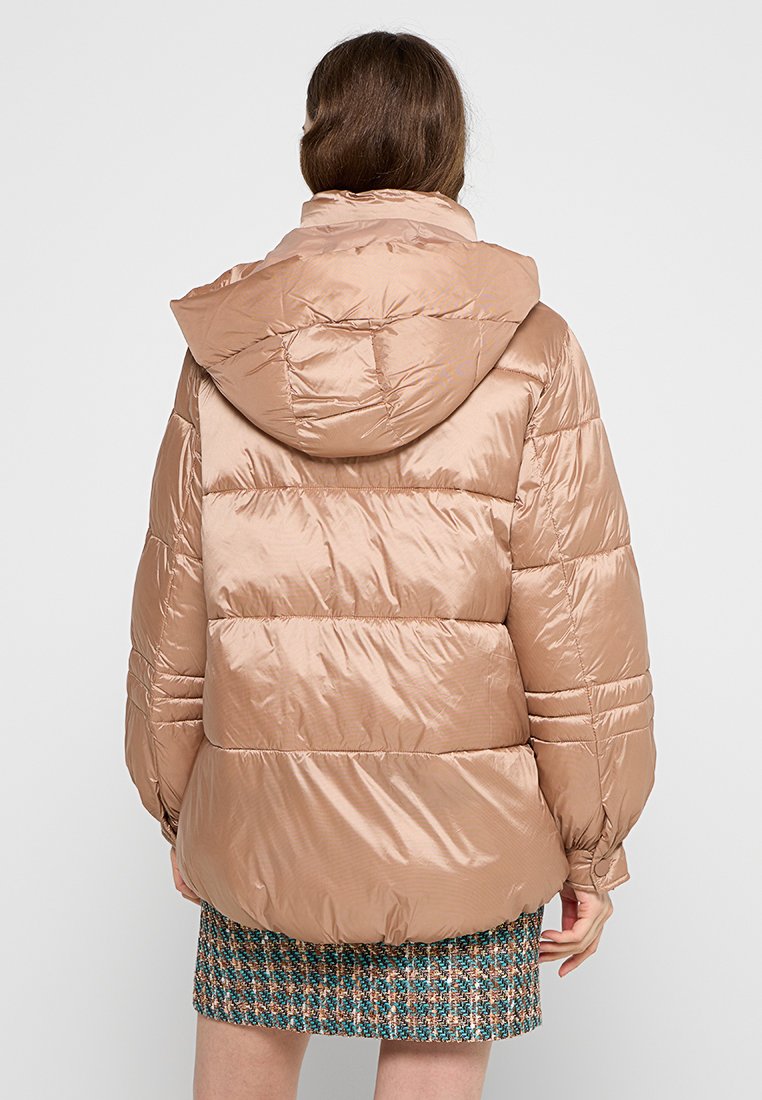 Jasnobrązowa kurtka puff z kapturem, z pikowanymi sekcjami, gładką fakturą i lekko błyszczącym wykończeniem.