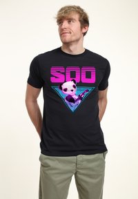 Černé bavlněné tričko s grafickým designem, na kterém je růžový nápis "SOO" a panda držící kytaru uvnitř tyrkysového trojúhelníku.