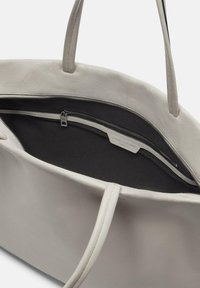 Graue Leder-Tote mit doppelten Griffen, einem Reißverschlussfach und einer Innenauskleidung aus schwarzem Stoff. Glatte Textur mit minimaler Detailgestaltung.