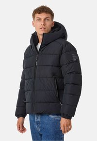 Czarna kurtka puchowa z kapturem, z pikowanym wzorem, z przodu na zamek błyskawiczny i ściągaczami na rękawach. Posiada haftowane logo na rękawie.