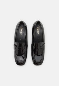 Mocassins en cuir verni noir avec une texture lisse, dotés d'un bout carré et d'un design de courroie supérieure modeste. Logo Gabor visible à l'intérieur.