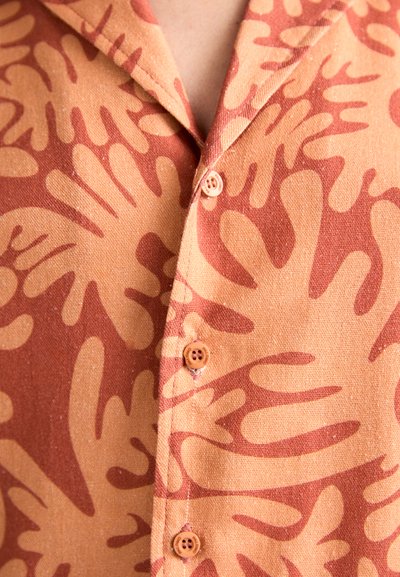 Button-up shirt in orange and light brown with a coral-like abstract pattern. Features a standard collar and four buttons on front.