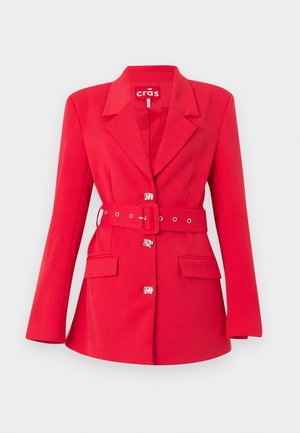 Crvena krojena jakna širokima reverima, srebrnim kukama za zatvaranje, džepovima s preklopom i odgovarajućim remenom s pravokutnom kopčom.