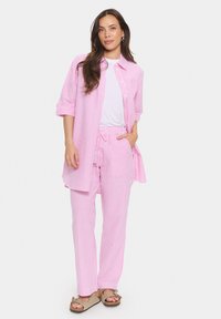 Pink striped shirt and matching pants set. The shirt has roll-up sleeves and a relaxed fit; the pants feature an elastic waistband and drawstring.