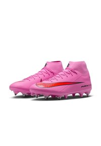 Lyserøde fodboldstøvler med en struktureret overdel, høj ankel design og sorte detaljer. Har en fremtrædende rød swoosh og klare studs.