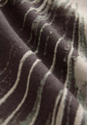 Tkanina drukowana z abstrakcyjnymi falistymi liniami w odcieniach ciemnoszarego i jasnego zielonego na beżowym tle, gładka tekstura z lekkim połyskiem.