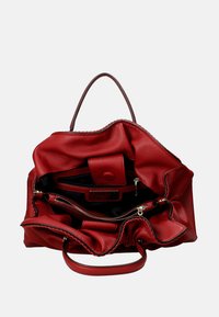 Borsa tote in pelle rossa con una finitura texturizzata, dotata di apertura superiore, tasche interne e un compartimento con zip. Le maniglie sono corte e robuste.