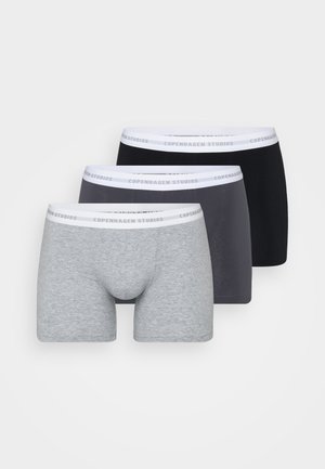 Schwarze Boxer Shorts mit einem weißen elastischen Bund, der mit "COPENHAGEN STUDIOS" beschriftet ist, taillierter Schnitt, glatte Textur und mittellange Länge bis zum Oberschenkel.