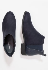 Stivaletti alla caviglia blu navy con una finitura in suede liscia, elastico sui lati e pannello posteriore testurizzato. Punta arrotondata e tacco in gomma basso.