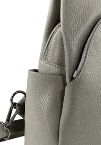 Gray textured leather backpack featuring a front zipper pocket and adjustable strap with silver hardware accents.