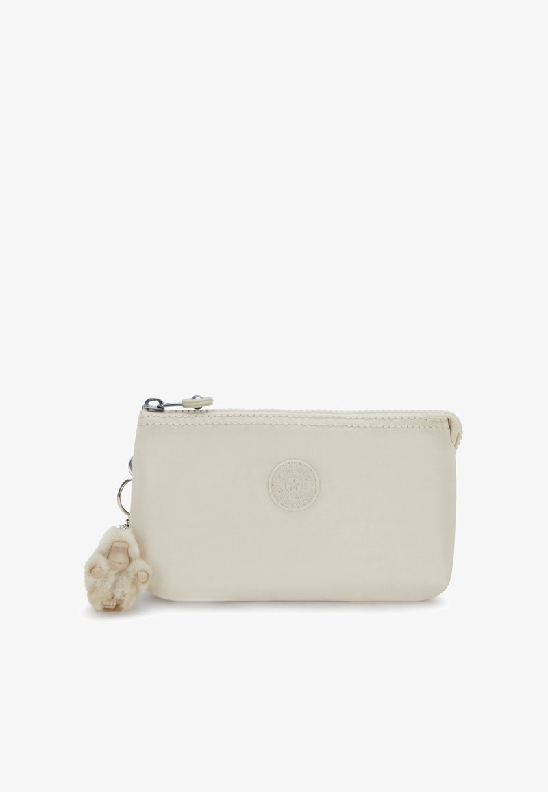 Funda de tela color crema con cierre de cremallera, que presenta un logo redondo y un llavero de felpa como adorno en el tirador de la cremallera.