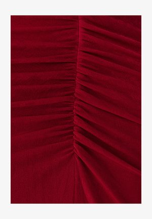 Rode stoffen jurk met verticale ruches. Gladde textuur en subtiele glans. Op maat gemaakte pasvorm met zachte draping over het lichaam.