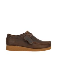 Hnědá kožená bota s zaoblenou špičkou, hnědými tkaničkami a strukturovanou gumovou podrážkou. Obsahuje visačku s logem "Clarks".