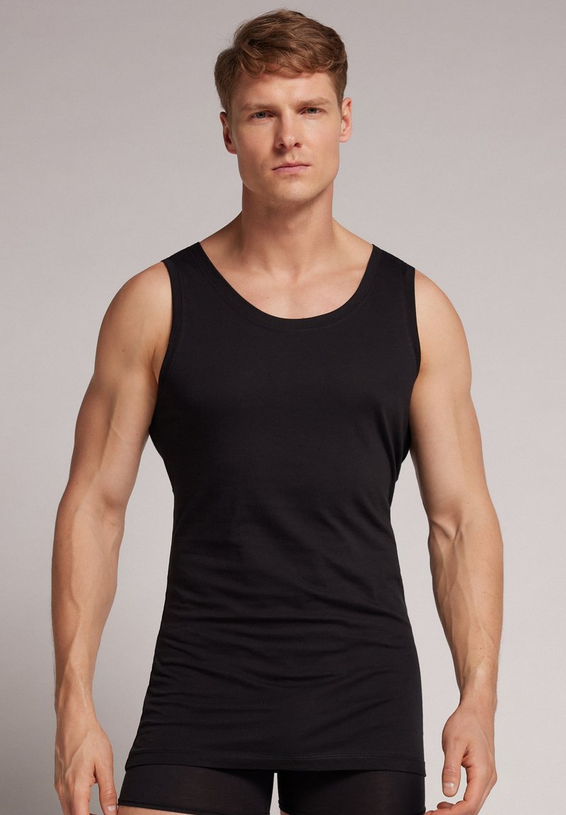 Schwarzes Baumwolltanktop mit einem klassischen Rundhalsausschnitt und ärmellosem Design, das eine figurbetonte Form und eine glatte Textur aufweist.