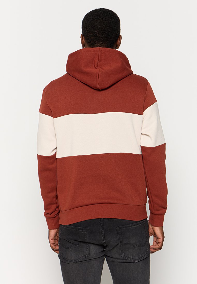 Haut à capuche à rayures rouille et crème avec un cordon de serrage, des poignets côtelés et un ourlet, fabriqué en tissu doux mélangé en coton. Vue de dos présentée.