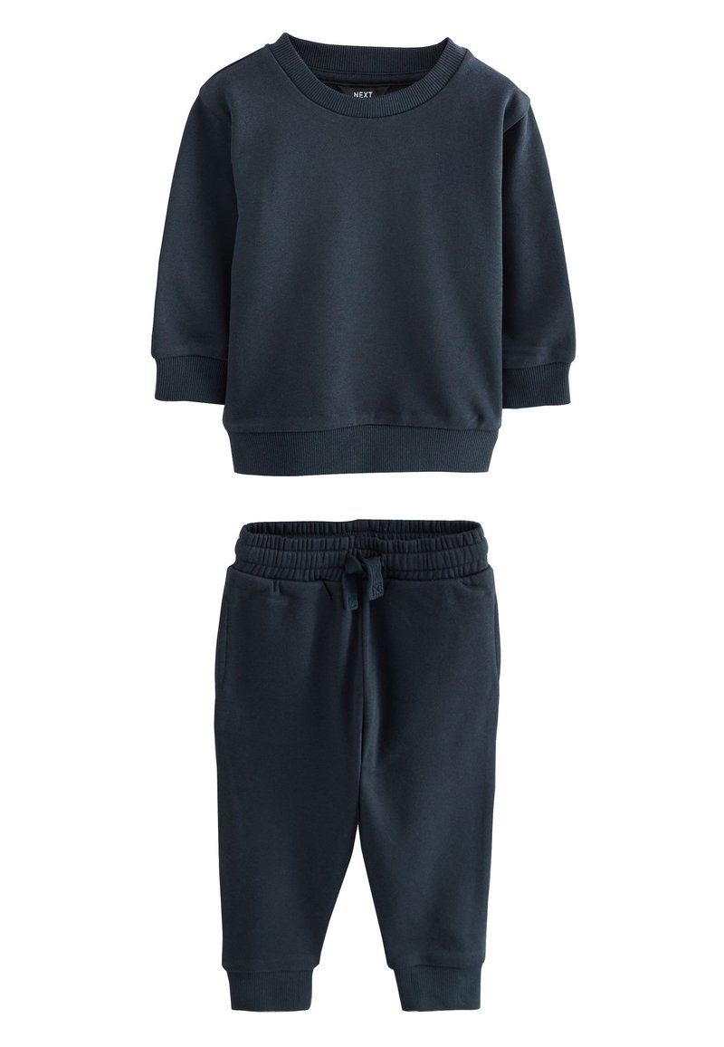 Sweat-shirt en coton bleu marine à manches longues et poignets côtelés, assorti d'un pantalon de jogging avec taille élastique et poches latérales.