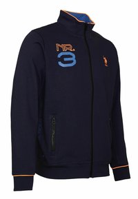 Námořnická zipová bunda s vysokým límcem, oranžovými detaily. Obsahuje výšivku "NR. 3" a loga, dvě boční kapsy na zip a žebrované manžety.