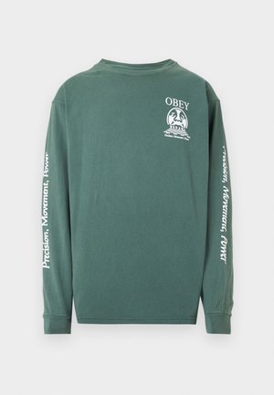 T-shirt à manches longues, vert, en coton avec un col rond. Le devant arbore le logo "OBEY" ; le texte sur les manches indique "Précision, Mouvement, Pouvoir" en blanc.