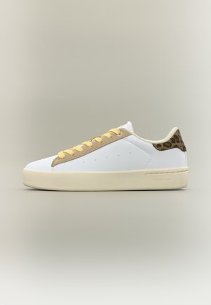 Λευκό sneaker χαμηλού ύψους με μπεζ κορδόνια, ταμπά περίγραμμα και λεπτομέρεια με λεοπάρ μοτίβο στη φτέρνα, τοποθετημένο σε ουδέτερο φόντο.