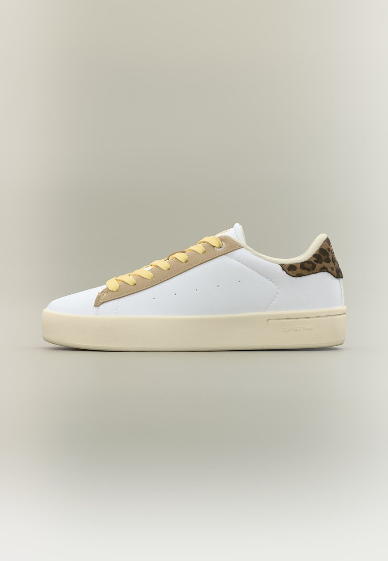 Baskets blanches basses avec des lacets beiges, une bordure couleur fauve et un détail imprimé léopard au talon, sur un fond neutre.