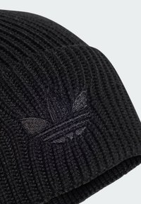 Strikket sort hue med lodret rib, der har en subtil sort logo detalje. Stoffet ser blødt og struktureret ud.