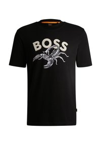 Svart bomull T-shirt med en vit grafisk bild av en skorpion och ordet "BOSS" i fet krämfärgade bokstäver. Rund halsringning och korta ärmar.