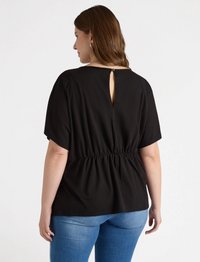 Schwarzes Shirt mit kurzen Ärmeln, elastischem Bund und einem Schlüsselrücken-Detail. Der Stoff wirkt glatt und leicht, geeignet für legere Kleidung.