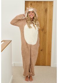 Bruin en crèmekleurig fluffy onesie met een capuchon, voorzien van een berengezicht, strikaccent op de kop en zachte stof. Loose fit en lange mouwen.