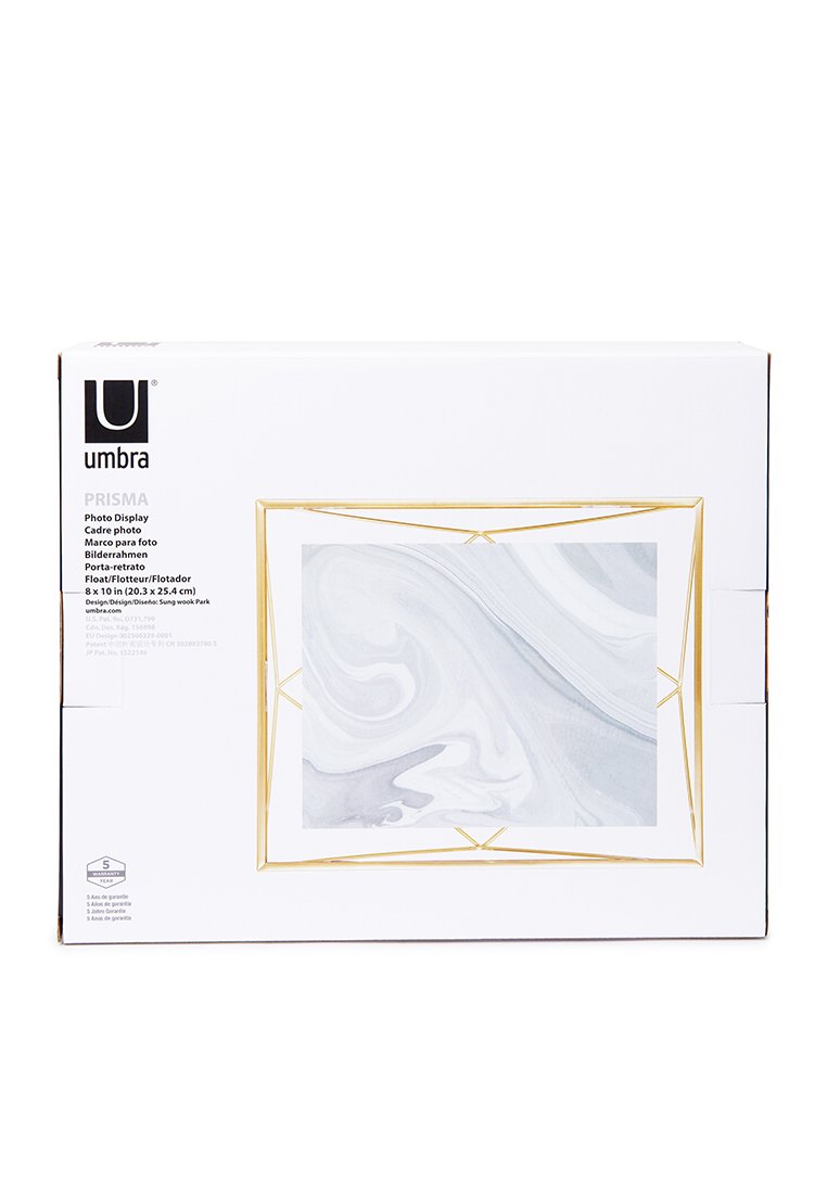 Emballage en boîte blanche pour l'affichage photo Umbra PRISMA ; comprend un cadre géométrique doré, un motif marbré blanc et gris, et peut accueillir des photos de 20x25 cm.